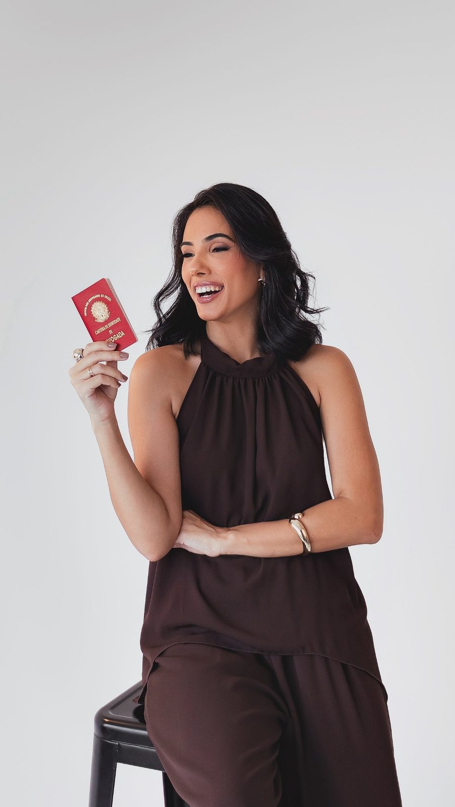 Amanda Medeiros Faria sorrindo e segurando a carteira da OAB
